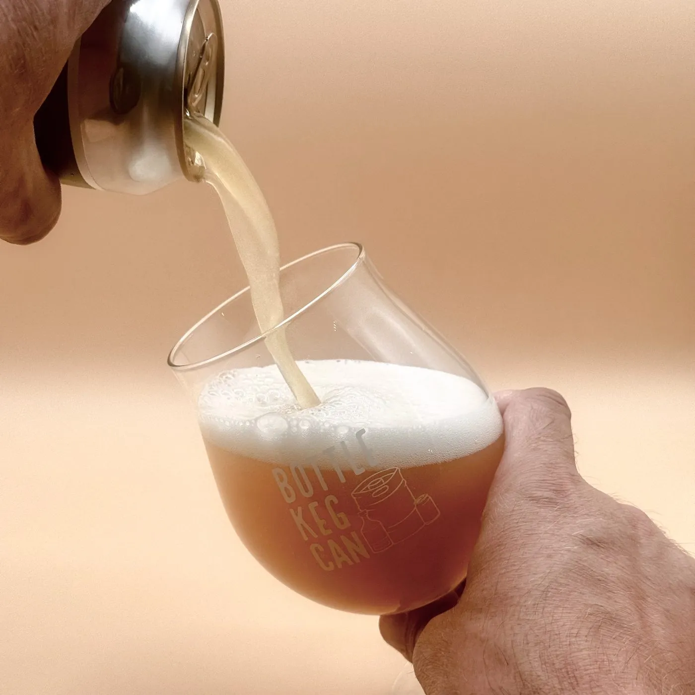 A hazy beer being poured into a Bottle Keg Can glass