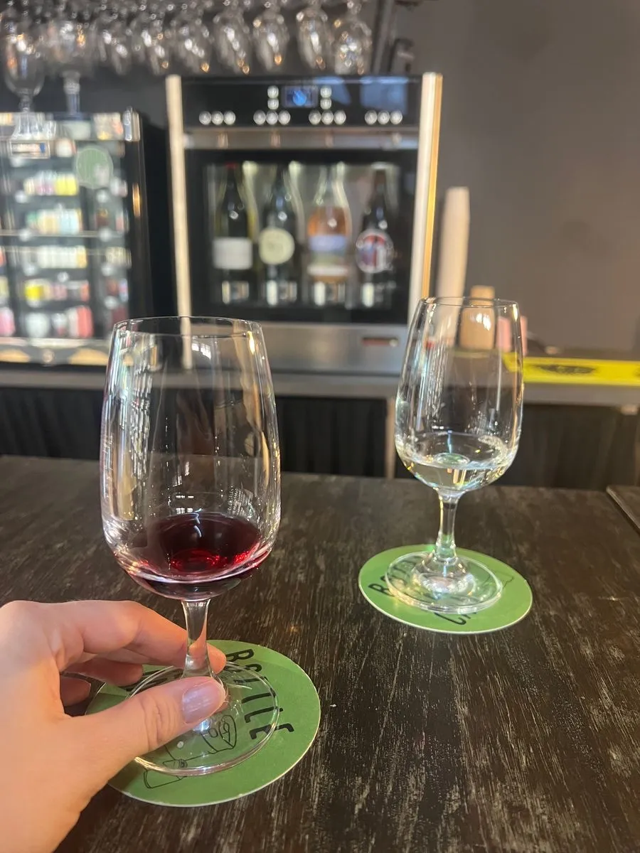 Two glasses of wine, a red and a white, at the table ready to taste at Bottle Keg Can